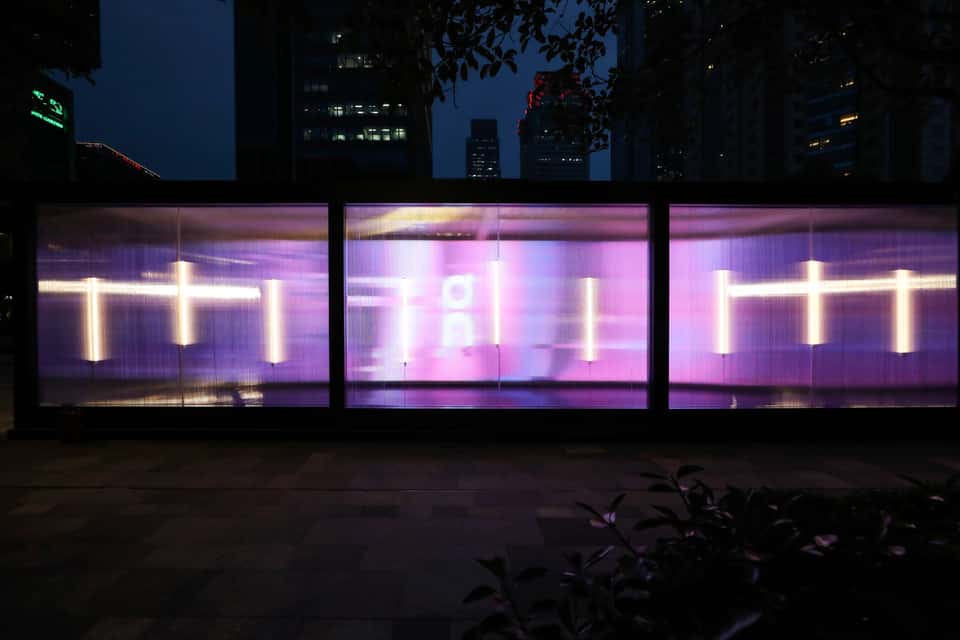 A view of an On Running store at night, the abstract visualization being blurred by the storefront glass.