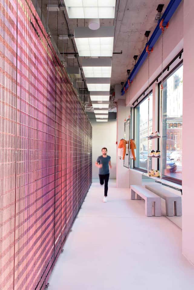 View of LED wall with a runner in front of the LED screen in an On Running store.