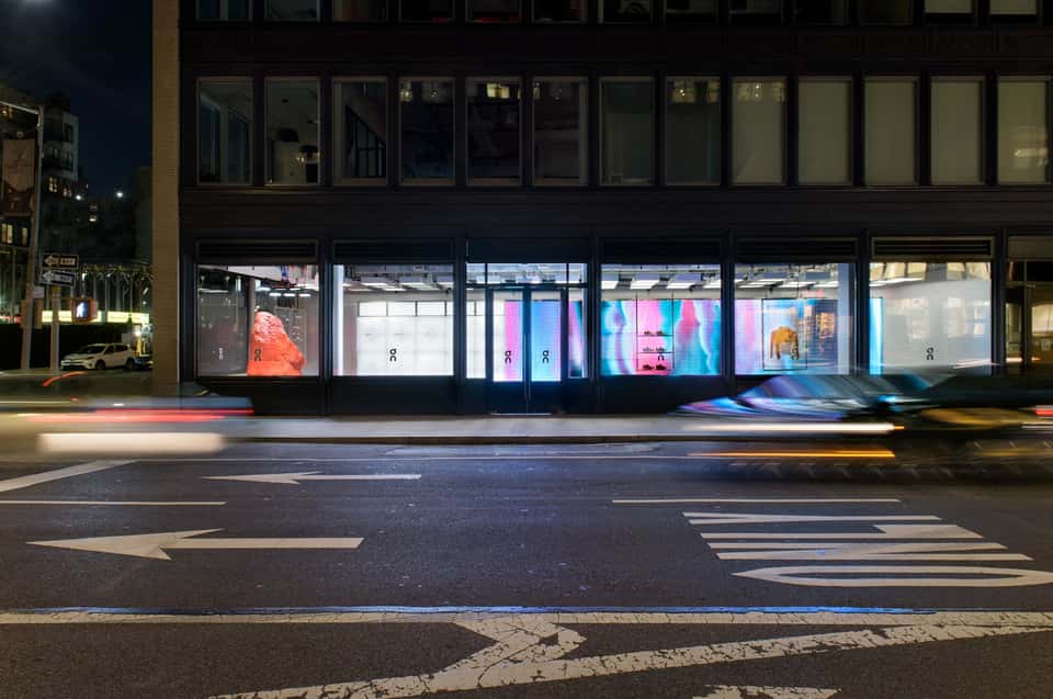 View of the On Running flagship store in New York showing the interactive installation with a large LED screen displaying an abstract visualization of a runner.